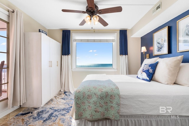 bedroom featuring multiple windows, visible vents, and a ceiling fan