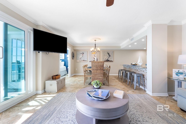 living area with an inviting chandelier, baseboards, and ornamental molding