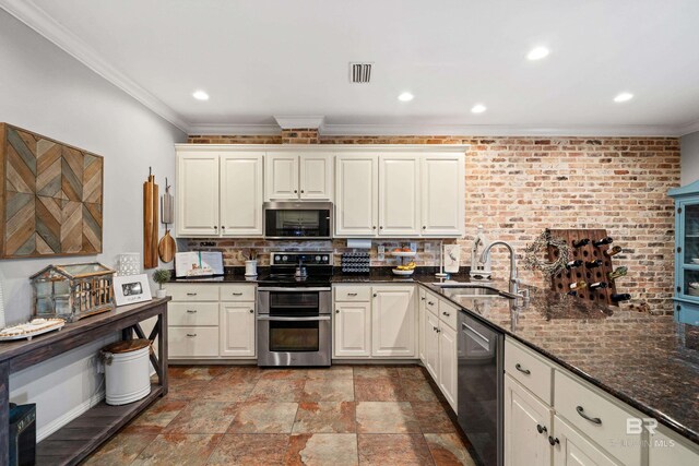 kitchen featuring a sink, appliances with stainless steel finishes, crown molding, and decorative backsplash
