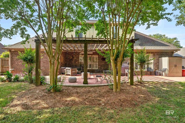 back of house featuring fence, a pergola, a patio, brick siding, and a storage shed
