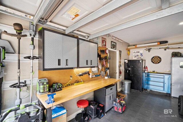 garage with black fridge and a workshop area