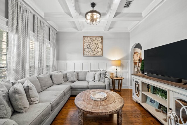 living area with visible vents, crown molding, arched walkways, beamed ceiling, and coffered ceiling
