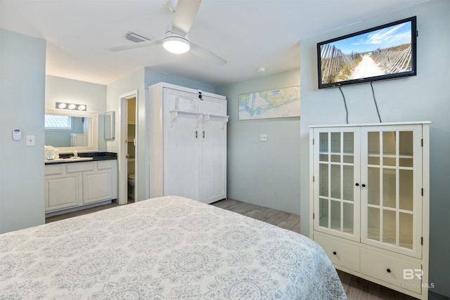 23044 Perdido Beach Blvd Unit 338, Orange Beach, AL 36561 - bedroom with wood finished floors, a sink, ensuite bathroom, and a ceiling fan