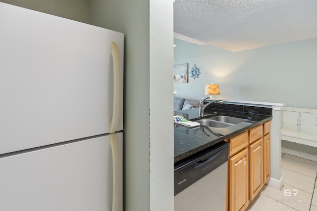 23044 Perdido Beach Blvd Unit 338, Orange Beach, AL 36561 - kitchen featuring freestanding refrigerator, stainless steel dishwasher, a sink, light tile patterned floors, and a textured ceiling