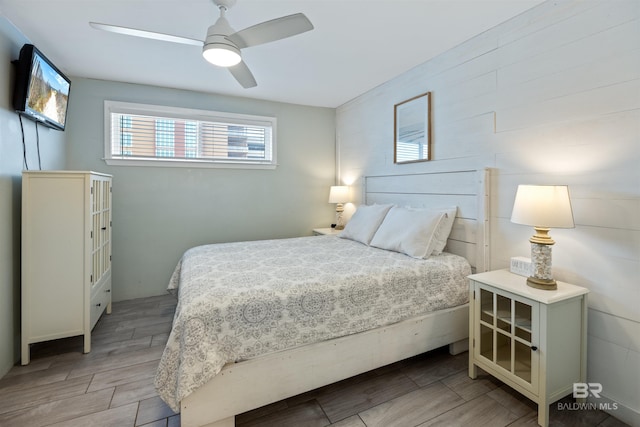 23044 Perdido Beach Blvd Unit 338, Orange Beach, AL 36561 - bedroom with light wood finished floors, ceiling fan, and wooden walls