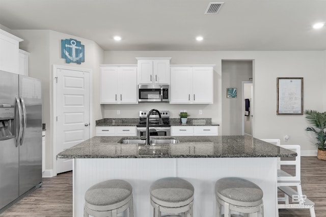 9365 Eiland Dr, Foley, AL 36535 - kitchen featuring stainless steel appliances, wood finished floors, baseboards, a kitchen breakfast bar, and recessed lighting