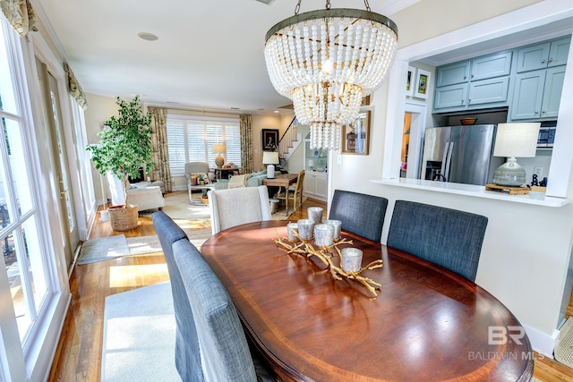 dining area featuring a chandelier, crown molding, and hardwood / wood-style floors