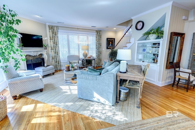 living room with crown molding and light hardwood / wood-style flooring