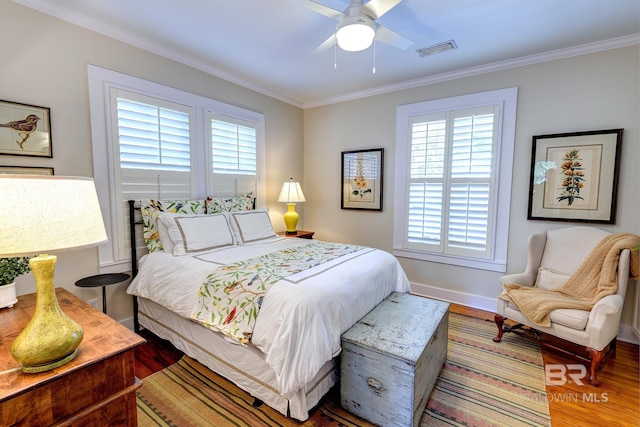 bedroom with hardwood / wood-style flooring, ornamental molding, and multiple windows