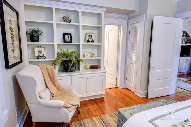 interior space with light wood-type flooring and crown molding