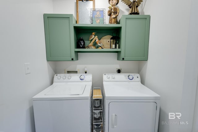 washroom featuring hookup for a washing machine, washing machine and clothes dryer, and cabinets