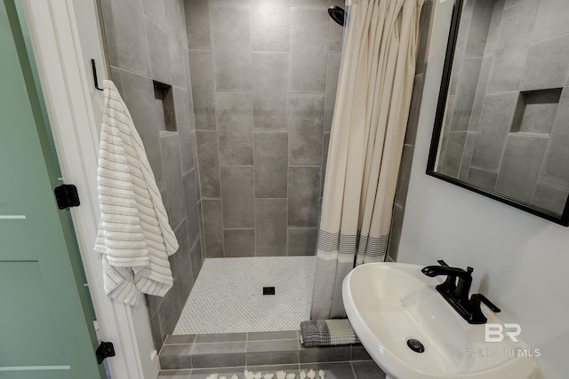 bathroom with curtained shower, sink, and tile flooring