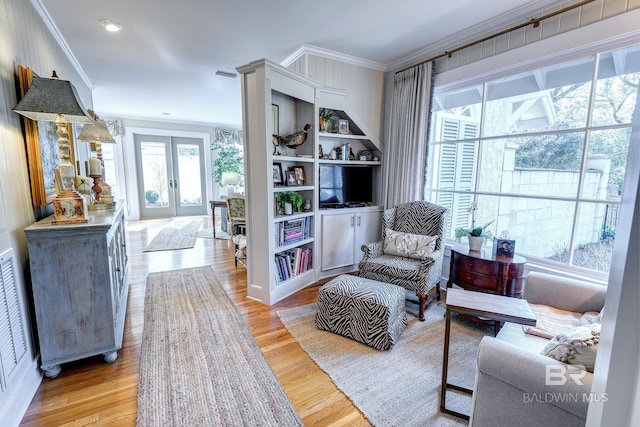 sitting room with crown molding, french doors, hardwood / wood-style flooring, and a wealth of natural light