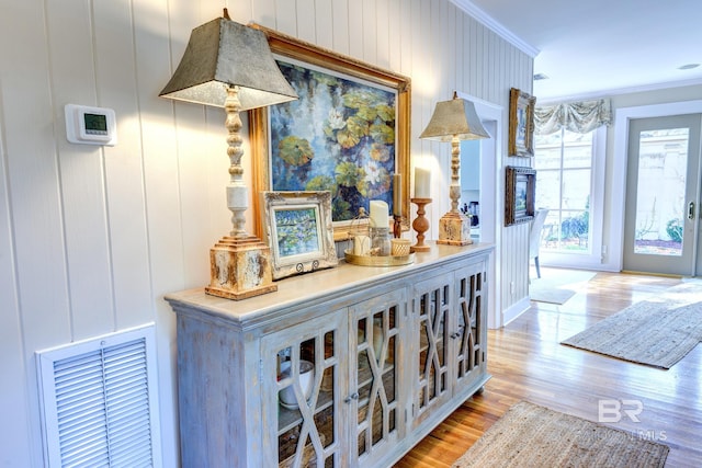 hall with ornamental molding and hardwood / wood-style floors