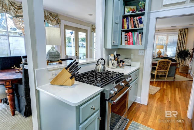 kitchen featuring high end stainless steel range oven, light hardwood / wood-style flooring, and french doors