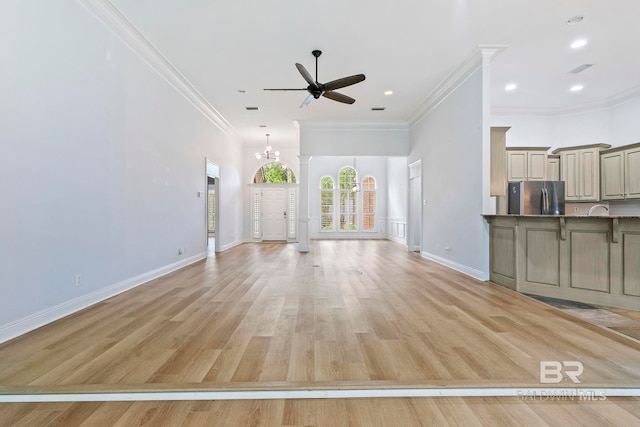 unfurnished living room featuring ceiling fan with notable chandelier, light wood-type flooring, and ornamental molding