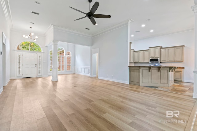 unfurnished living room with ornamental molding, ceiling fan with notable chandelier, decorative columns, and light hardwood / wood-style floors