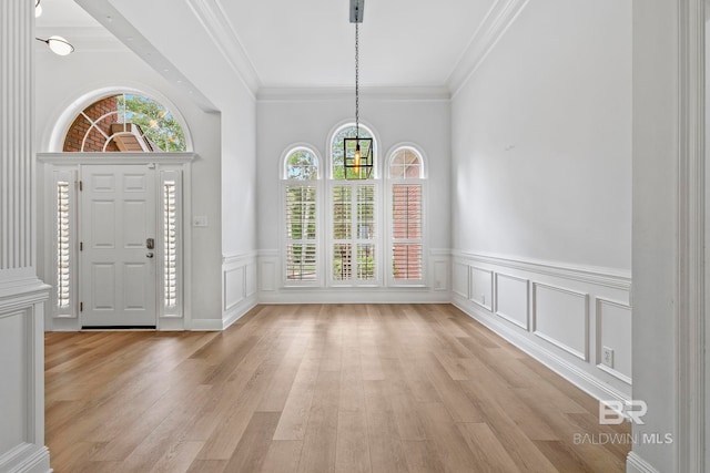 foyer entrance featuring light wood-type flooring and ornamental molding