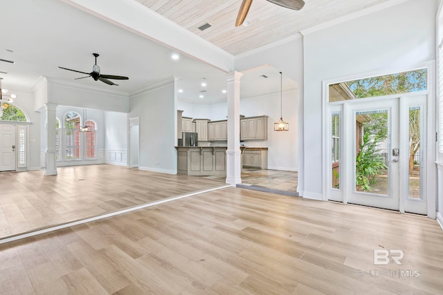 unfurnished living room featuring ceiling fan, light wood-type flooring, and ornate columns