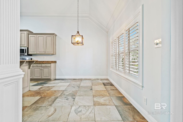 kitchen featuring lofted ceiling, ornamental molding, and pendant lighting