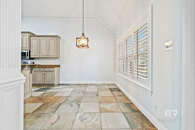 kitchen featuring appliances with stainless steel finishes, a kitchen bar, ornamental molding, and light stone countertops