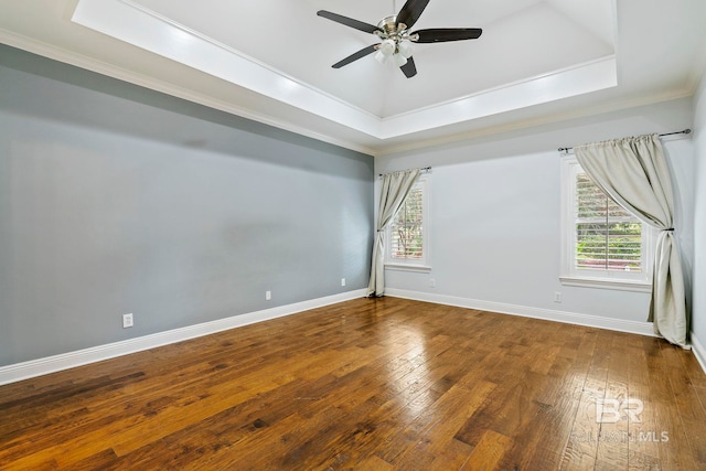 unfurnished room with a tray ceiling, ceiling fan, hardwood / wood-style flooring, and a healthy amount of sunlight