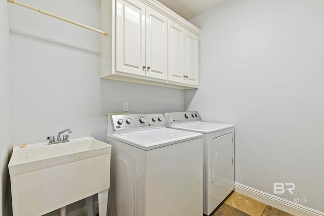 laundry room with cabinets, independent washer and dryer, and sink