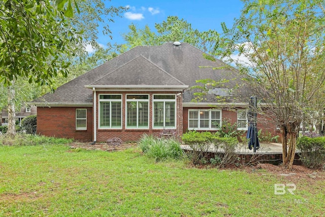 rear view of property featuring a lawn