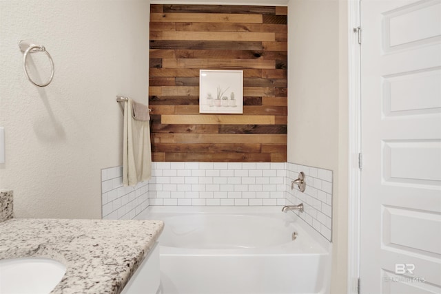 bathroom with a washtub and vanity