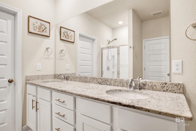 bathroom featuring vanity and a shower with door