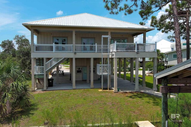 back of house with a patio area and a lawn