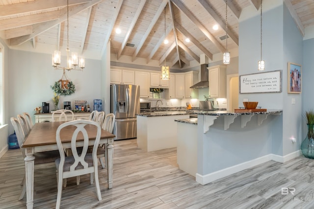 kitchen with wood ceiling, hanging light fixtures, appliances with stainless steel finishes, and dark stone counters