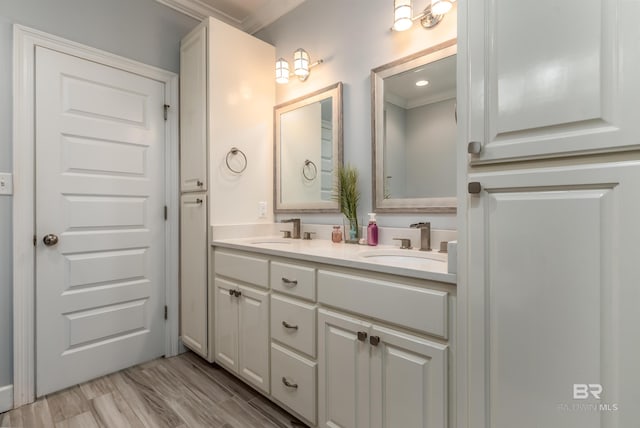 bathroom with hardwood / wood-style flooring, vanity, and crown molding