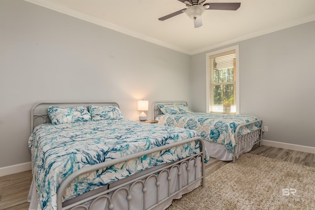 bedroom with light hardwood / wood-style flooring, ceiling fan, and crown molding