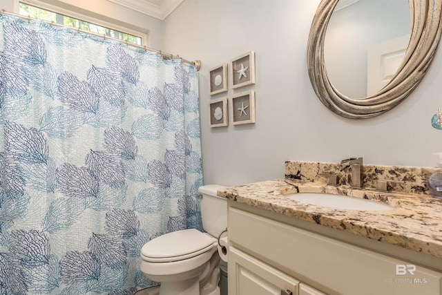 bathroom with toilet, vanity, and ornamental molding