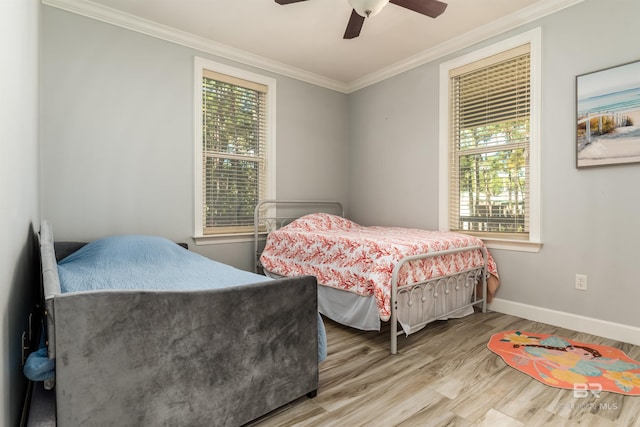 bedroom with multiple windows, light hardwood / wood-style flooring, ceiling fan, and ornamental molding