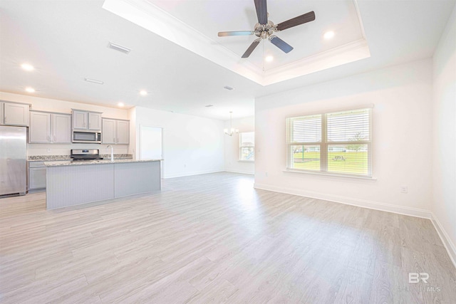 394 Haise Ln, Gulf Shores, AL 36542 - kitchen featuring stainless steel appliances, gray cabinets, open floor plan, a tray ceiling, and recessed lighting
