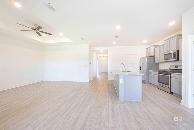 394 Haise Ln, Gulf Shores, AL 36542 - kitchen featuring stainless steel appliances, gray cabinets, a sink, a ceiling fan, and a kitchen island with sink