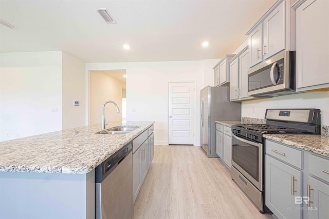 394 Haise Ln, Gulf Shores, AL 36542 - kitchen with stainless steel appliances, a sink, gray cabinets, a center island with sink, and recessed lighting