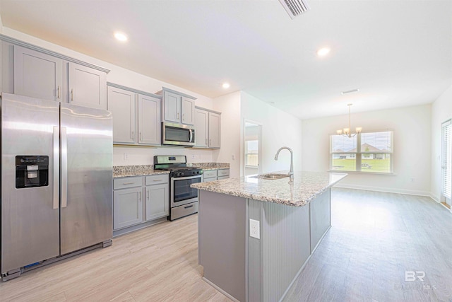 394 Haise Ln, Gulf Shores, AL 36542 - kitchen with appliances with stainless steel finishes, a sink, gray cabinetry, a chandelier, and light stone countertops