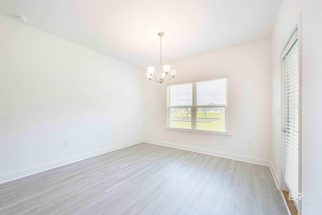 394 Haise Ln, Gulf Shores, AL 36542 - unfurnished room with light wood-style floors, a chandelier, a smoke detector, and baseboards