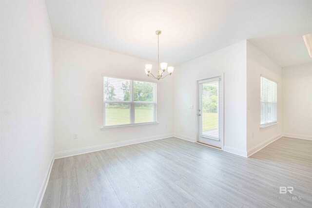 394 Haise Ln, Gulf Shores, AL 36542 - empty room featuring light wood-style flooring, a chandelier, and baseboards