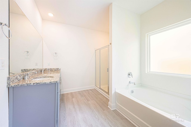 394 Haise Ln, Gulf Shores, AL 36542 - full bathroom with wood finished floors, double vanity, a garden tub, a shower stall, and baseboards