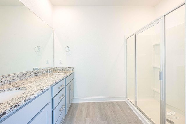 394 Haise Ln, Gulf Shores, AL 36542 - full bath featuring wood finished floors, double vanity, a shower stall, and baseboards