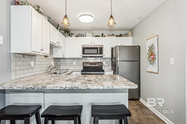 kitchen featuring white cabinetry, stainless steel appliances, kitchen peninsula, and sink