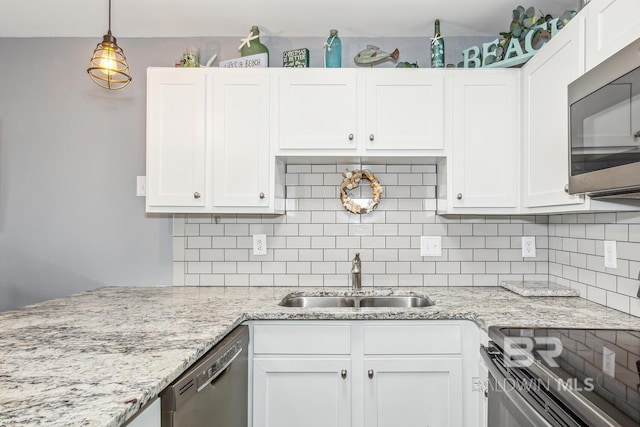 kitchen featuring dishwasher, sink, white cabinetry, hanging light fixtures, and light stone counters