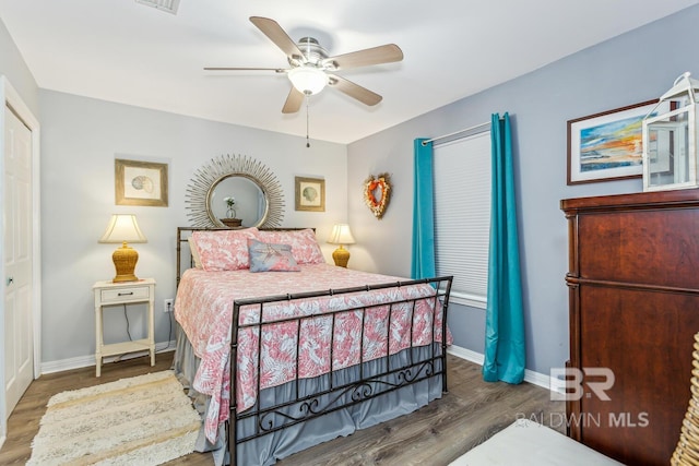 bedroom with ceiling fan, a closet, and dark hardwood / wood-style floors