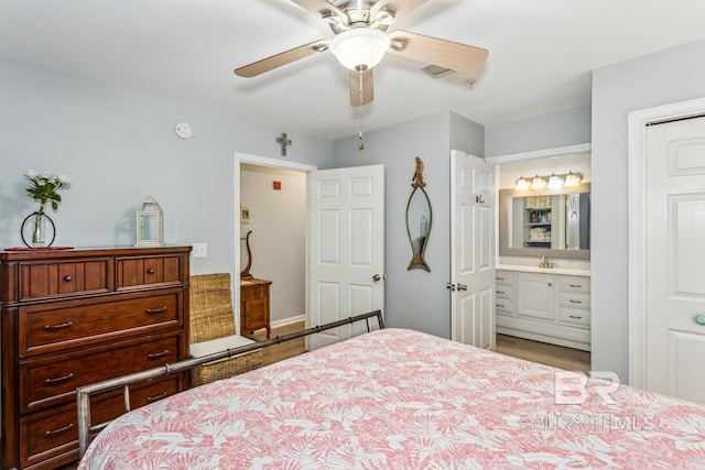 bedroom with ceiling fan, sink, and ensuite bath