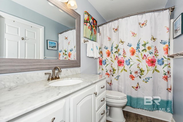 bathroom featuring toilet, a shower with curtain, hardwood / wood-style floors, and vanity