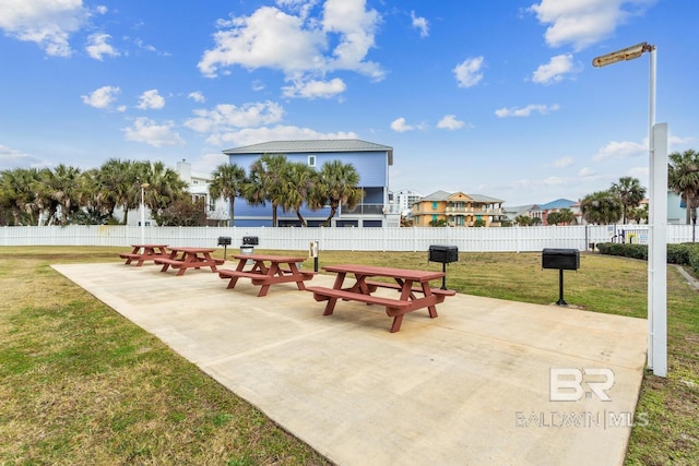 view of property's community with a lawn and a patio